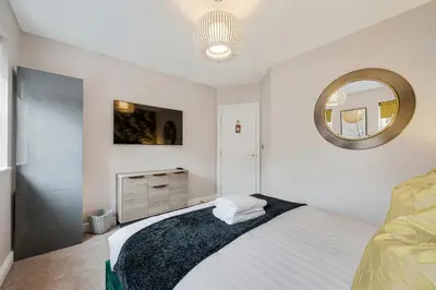 a white bedroom with a bed and a mirror at 3BR Georgian Quarter Coach Houses - Private Parking in Liverpool