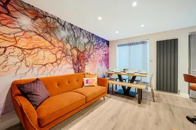 a living room with an orange couch and a table at 3BR Georgian Quarter Coach Houses - Private Parking in Liverpool