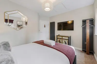 a bedroom with a white bed and a mirror at 3BR Georgian Quarter Coach Houses - Private Parking in Liverpool