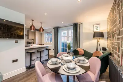 a living room with a table and chairs and a kitchen at 3BR Georgian Quarter Coach Houses - Private Parking in Liverpool