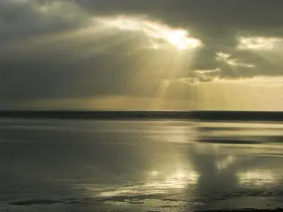 a view of the ocean with the sun shining through the clouds at Priory View in Ulverston