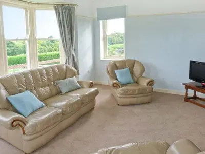 a living room with a couch and two chairs at Priory View in Ulverston