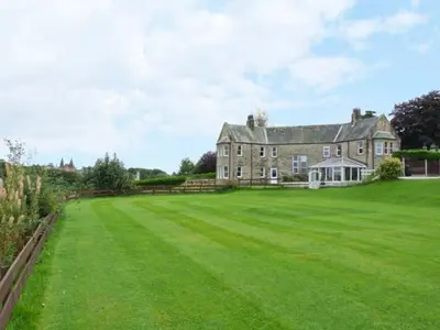 a large house with a large grass yard at Priory View in Ulverston