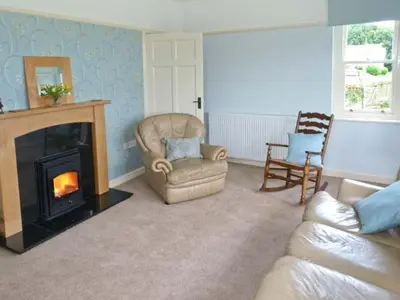 a living room with a chair and a fireplace at Priory View in Ulverston