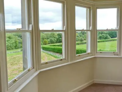 a room with four windows with a view of a field at Priory View in Ulverston