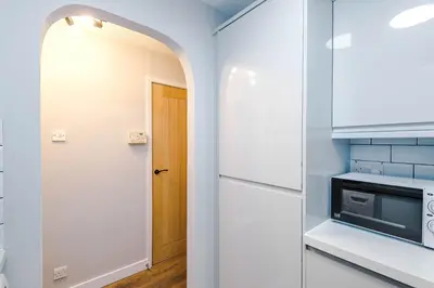 a kitchen with a white refrigerator and a door at Long Stays Offers , New 2 Bed APT , Sleeps 3 , Wigan , Perfect for Relocations , Contractors , Families in Ince-in-Makerfield