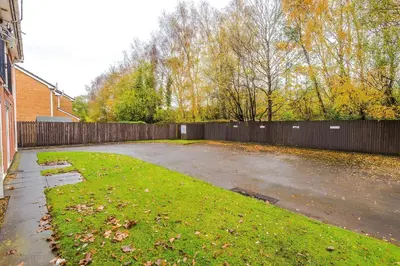 an empty parking lot with a fence in a yard at Long Stays Offers , New 2 Bed APT , Sleeps 3 , Wigan , Perfect for Relocations , Contractors , Families in Ince-in-Makerfield