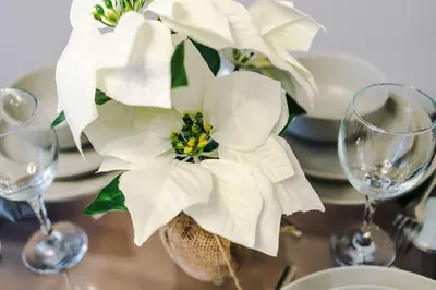 a vase with white flowers on a table with glasses at Long Stays Offers , New 2 Bed APT , Sleeps 3 , Wigan , Perfect for Relocations , Contractors , Families in Ince-in-Makerfield