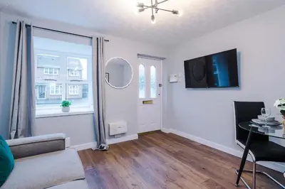 a living room with a couch and a table and a tv at Long Stays Offers , New 2 Bed APT , Sleeps 3 , Wigan , Perfect for Relocations , Contractors , Families in Ince-in-Makerfield