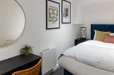 a bedroom with a bed and a mirror at Cozy 2 Beds Apt, Sleeps 8 with FREE parking in Liverpool