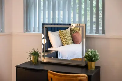 a mirror on a desk with a bed in a bedroom at Cozy 2 Beds Apt, Sleeps 8 with FREE parking in Liverpool