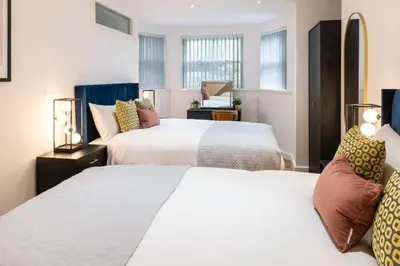 a hotel room with two beds and two lamps at Cozy 2 Beds Apt, Sleeps 8 with FREE parking in Liverpool