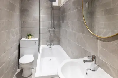 a bathroom with a toilet and a sink and a tub at Cozy 2 Beds Apt, Sleeps 8 with FREE parking in Liverpool