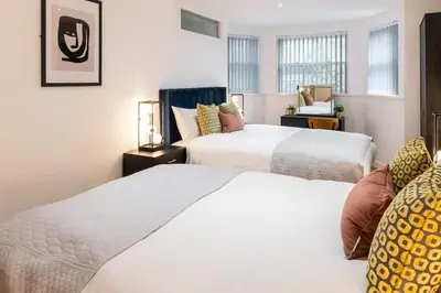 a bedroom with two beds and a window at Cozy 2 Beds Apt, Sleeps 8 with FREE parking in Liverpool