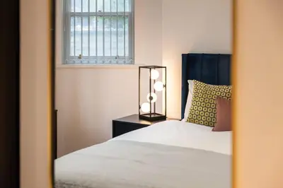 a bedroom with a bed and a window at Cozy 2 Beds Apt, Sleeps 8 with FREE parking in Liverpool