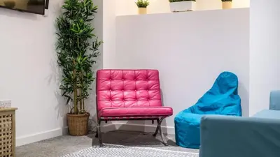 a pink chair and a blue chair in a room at The Bloc - Liverpool Nightlife Apartments in Liverpool