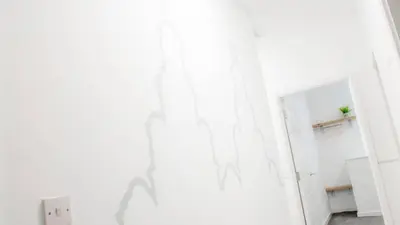 a white room with a door and a mirror at The Bloc - Liverpool Nightlife Apartments in Liverpool