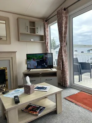 a living room with a television and a table with a table at Haven Cala gran in 2026 through to Jan 2027 spring summer winter breaks Blackpool Fleetwood entire home 6 people seaside holiday park in Fleetwood