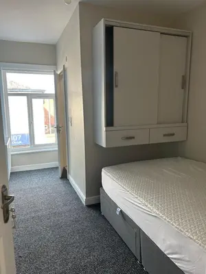 a bedroom with a bed with a dresser and a window at Westfield Street in Saint Helens