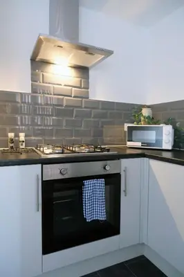 a kitchen with a stove with a towel on the oven at Whitland House by Serviced Living Liverpool in Liverpool