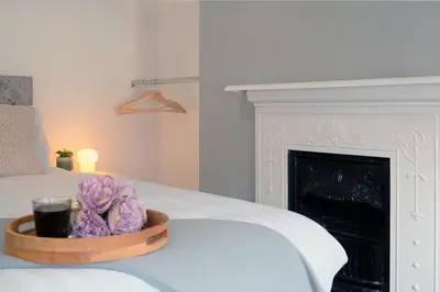 a bowl of flowers on a bed with a fireplace at Whitland House by Serviced Living Liverpool in Liverpool