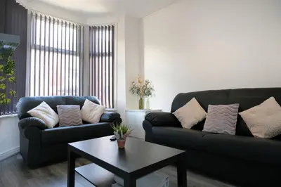 a living room with two couches and a coffee table at Whitland House by Serviced Living Liverpool in Liverpool