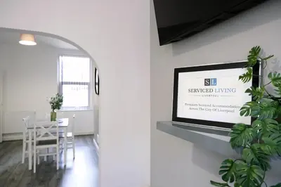 a framed sign on a wall in a living room at Whitland House by Serviced Living Liverpool in Liverpool
