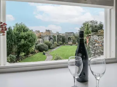 a bottle of wine and two glasses sitting on a window sill at Ullswater in Ulverston