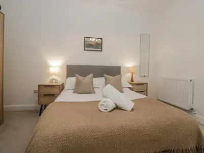 a bedroom with a large bed with two pillows at Derwent in Ulverston