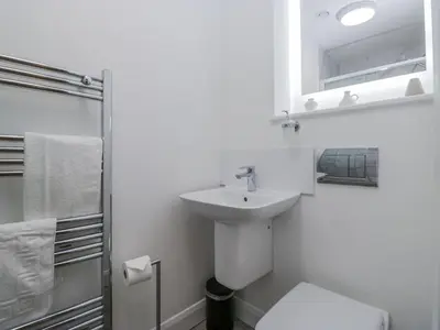 a white bathroom with a sink and a shower at Derwent in Ulverston