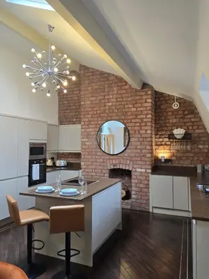 a kitchen with a brick wall and a chandelier at City Centre Luxury Apartment in Liverpool