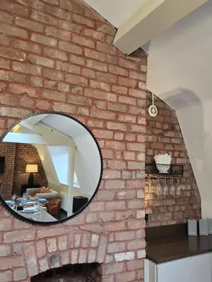 a brick wall with a round mirror on it at City Centre Luxury Apartment in Liverpool