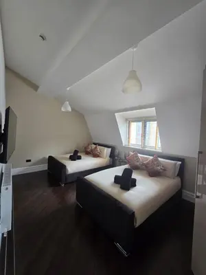 a bedroom with two beds and a tv in it at City Centre Luxury Apartment in Liverpool
