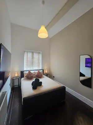 a bedroom with a bed with a teddy bear on it at City Centre Luxury Apartment in Liverpool