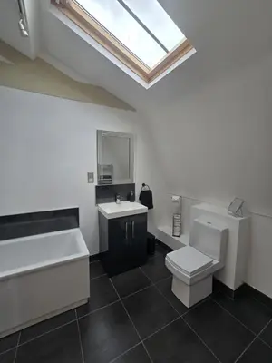 a bathroom with a toilet and a sink and a skylight at City Centre Luxury Apartment in Liverpool