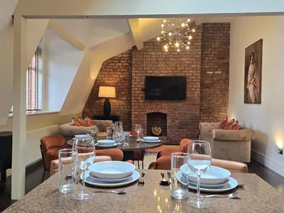 a dining room with a table and chairs and a fireplace at City Centre Luxury Apartment in Liverpool