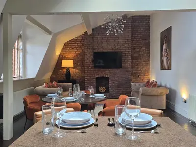 a dining room with a table and chairs and a fireplace at City Centre Luxury Apartment in Liverpool