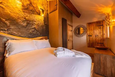 a bedroom with a large bed with white sheets at Spa Cottage - Hot Tub, Cold Pod & Sauna in Morecambe