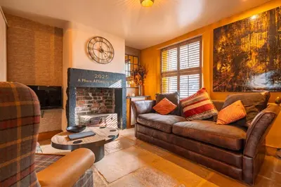 a living room with a couch and a fireplace at Spa Cottage - Hot Tub, Cold Pod & Sauna in Morecambe