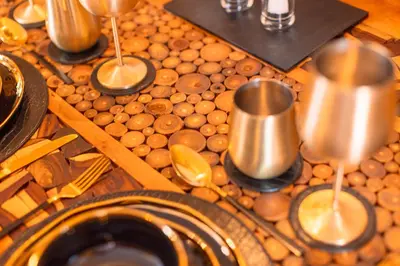 a table with wine glasses on top of logs at Spa Cottage - Hot Tub, Cold Pod & Sauna in Morecambe