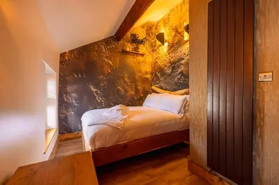 a bedroom with a bed with a wall at Spa Cottage - Hot Tub, Cold Pod & Sauna in Morecambe