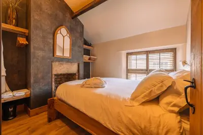 a bedroom with a bed and a fireplace at Spa Cottage - Hot Tub, Cold Pod & Sauna in Morecambe