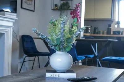 a white vase with flowers on a table at Modern 3-Bedroom Home - Contractor Friendly - Sleeps 5 - FAST WiFi - Parking in Seacombe