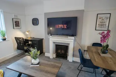 a living room with a fireplace with a tv above it at Modern 3-Bedroom Home - Contractor Friendly - Sleeps 5 - FAST WiFi - Parking in Seacombe