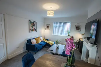 a living room with a blue couch and a table at Modern 3-Bedroom Home - Contractor Friendly - Sleeps 5 - FAST WiFi - Parking in Seacombe