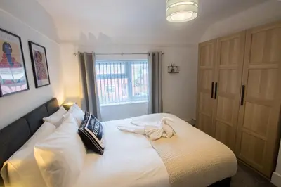 a bedroom with a bed with white sheets and a window at Modern 3-Bedroom Home - Contractor Friendly - Sleeps 5 - FAST WiFi - Parking in Seacombe