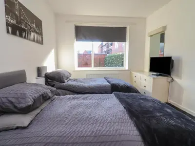 two beds in a bedroom with a window at Beach Side Bungalow in Lytham St Annes