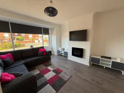 a living room with a couch and a fireplace at Beach Side Bungalow in Lytham St Annes