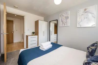 a bedroom with a bed and a dresser and a mirror at Central 2 Bed Apt with Balcony in Liverpool