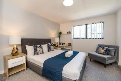 a bedroom with a large bed and a chair at Central 2 Bed Apt with Balcony in Liverpool